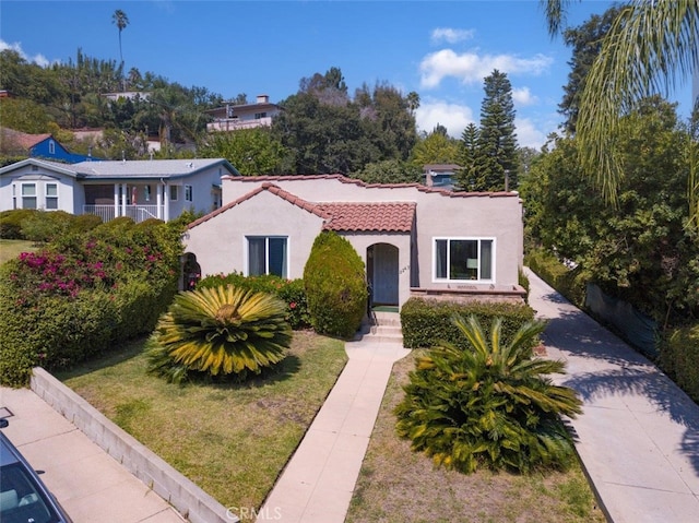 mediterranean / spanish house featuring a balcony and a front lawn