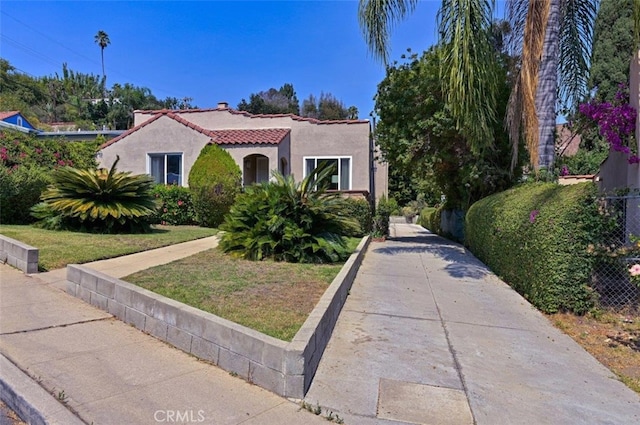 mediterranean / spanish home with a front lawn