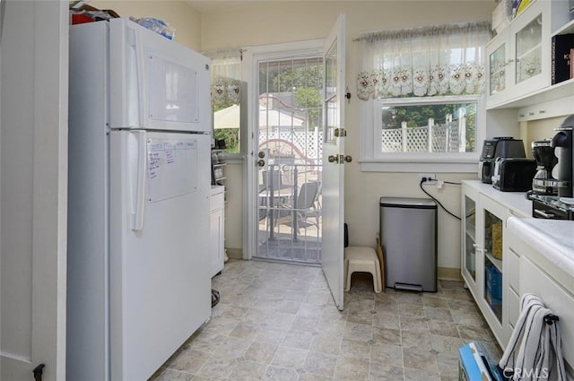 kitchen with white cabinetry and white fridge