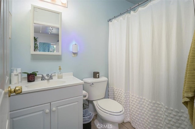 bathroom featuring vanity, tile patterned flooring, toilet, and curtained shower