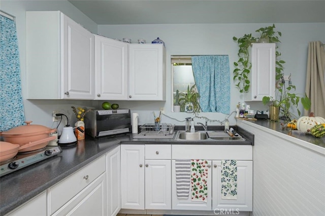 kitchen featuring white cabinets and sink