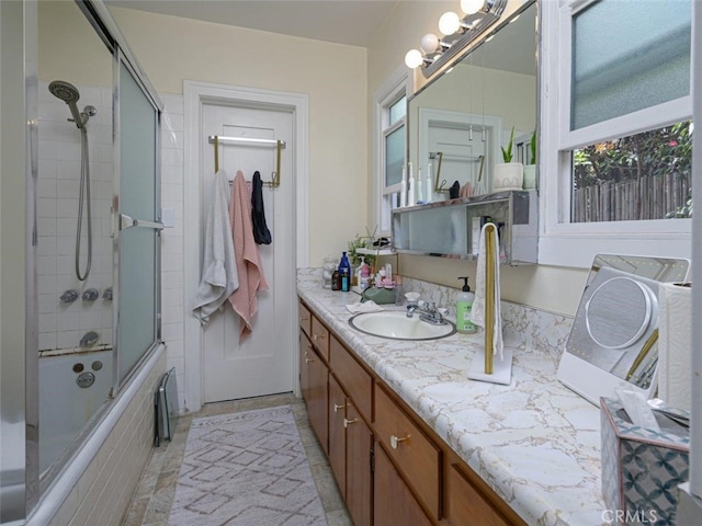 bathroom featuring enclosed tub / shower combo and vanity