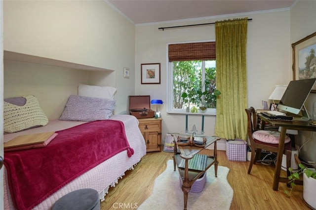 bedroom featuring light wood-type flooring and ornamental molding