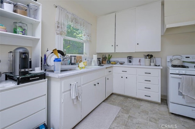 kitchen featuring white cabinets, white range oven, and sink