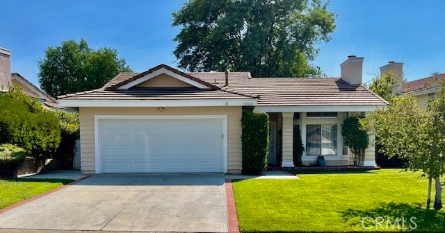 ranch-style home with a garage and a front lawn