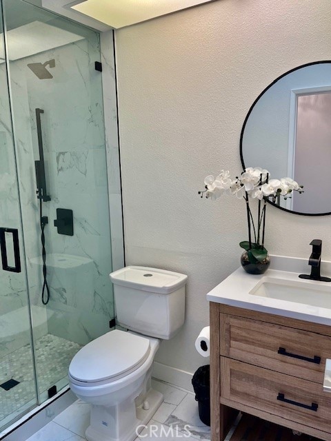 bathroom featuring tile patterned floors, a shower with shower door, vanity, and toilet