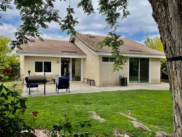 rear view of property featuring a lawn, a patio area, and central AC