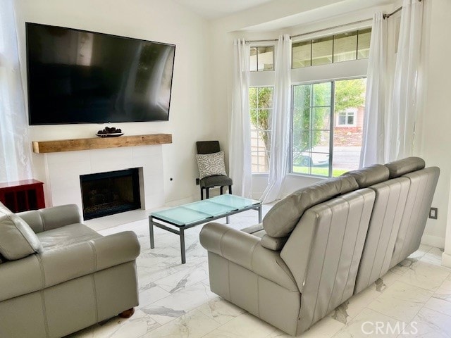 living room with a tiled fireplace and vaulted ceiling