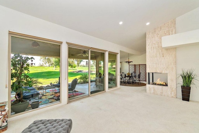 carpeted living room featuring a multi sided fireplace and vaulted ceiling