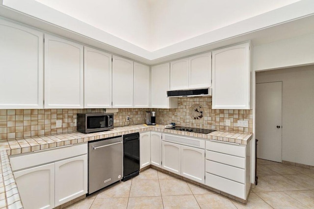 kitchen with white cabinetry, appliances with stainless steel finishes, and tile counters