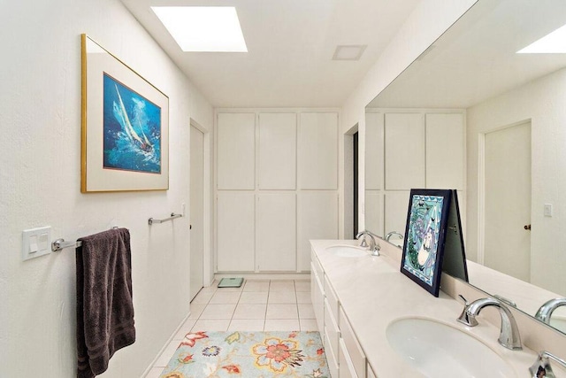 bathroom featuring tile patterned flooring, a skylight, and vanity