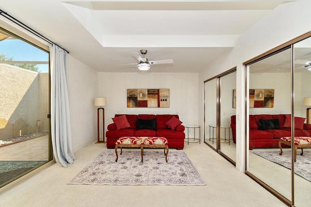 carpeted living room with ceiling fan