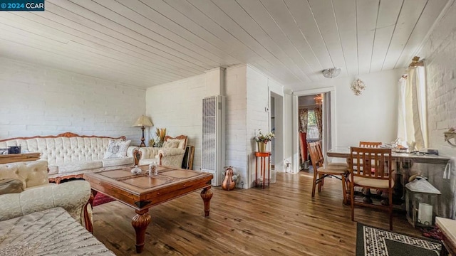 living room with wooden ceiling, wood-type flooring, and brick wall