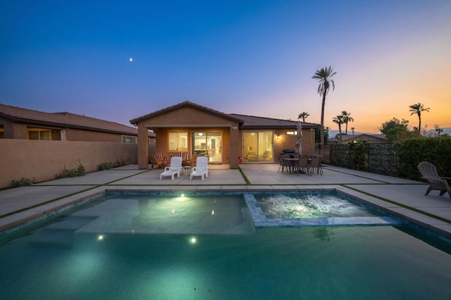 pool at dusk with a patio area