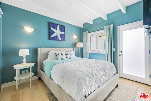 bedroom with beamed ceiling and light hardwood / wood-style floors