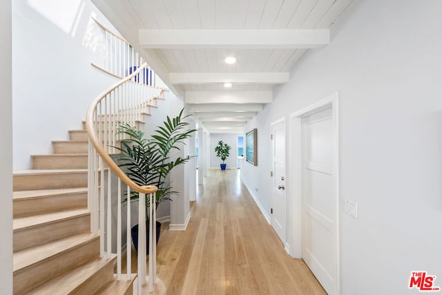 hallway featuring light hardwood / wood-style flooring, beam ceiling, and wooden ceiling