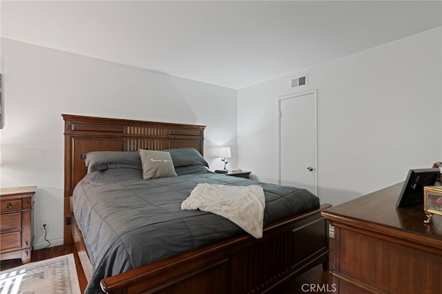 bedroom with dark hardwood / wood-style floors