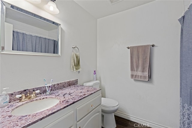 bathroom featuring wood-type flooring, vanity, and toilet