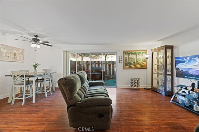 living room with ceiling fan and dark hardwood / wood-style flooring