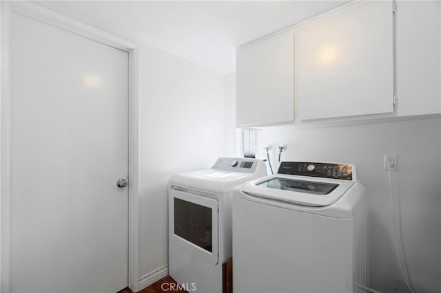 clothes washing area with cabinets and washer and clothes dryer