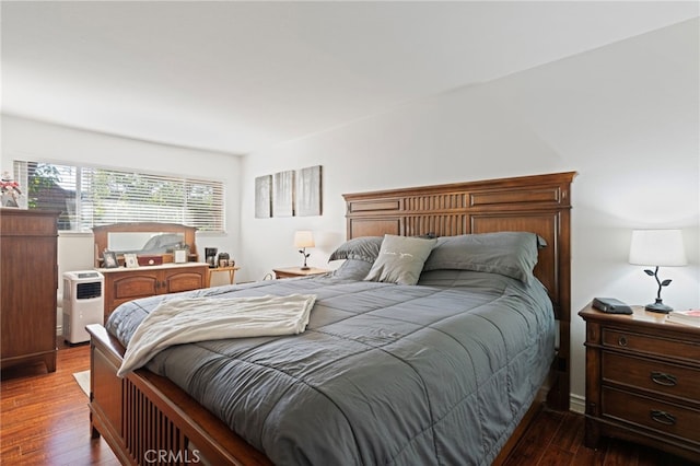 bedroom with dark hardwood / wood-style floors