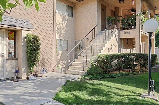 property entrance featuring ceiling fan and a yard