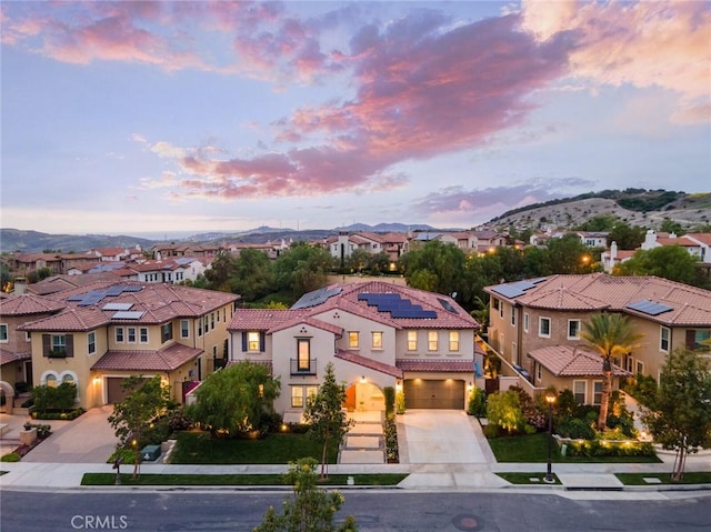 mediterranean / spanish house featuring solar panels, a garage, and a mountain view