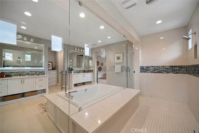 bathroom featuring backsplash, tile patterned flooring, vanity, and shower with separate bathtub