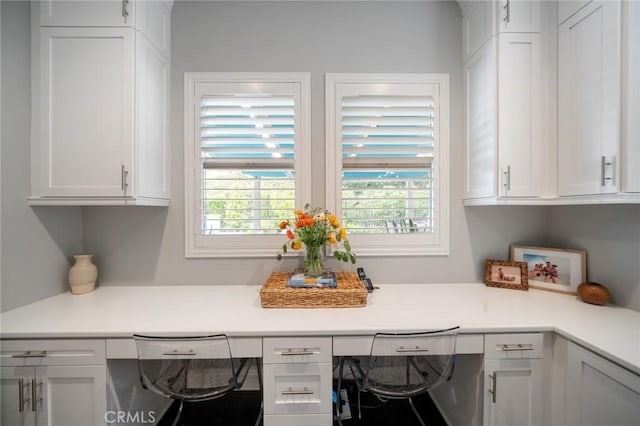 kitchen featuring built in desk and white cabinetry