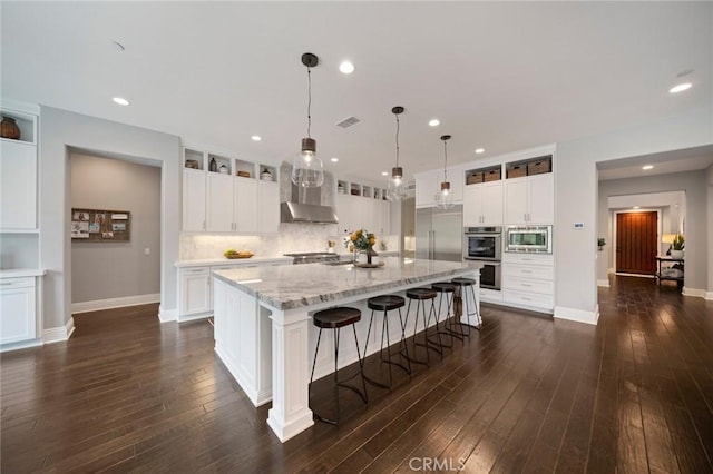 kitchen featuring built in appliances, dark hardwood / wood-style flooring, white cabinets, and a spacious island