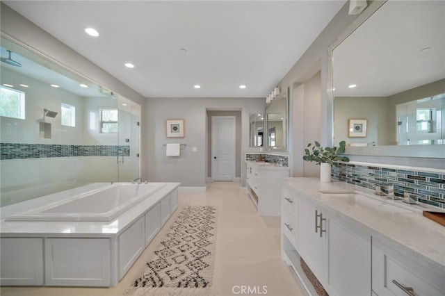 bathroom with backsplash, a bathtub, and vanity