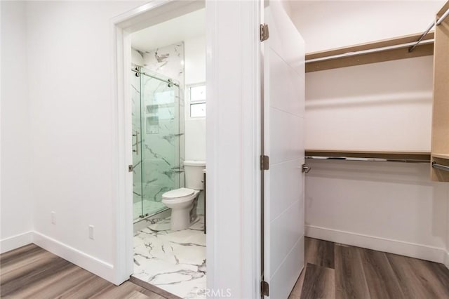 bathroom featuring hardwood / wood-style flooring and a shower with shower door