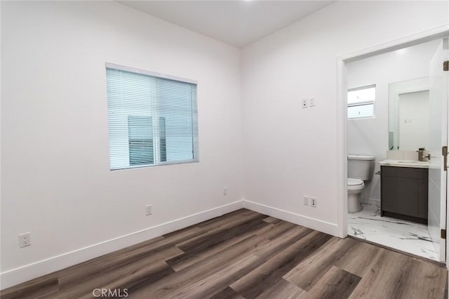 interior space with toilet, vanity, and hardwood / wood-style flooring