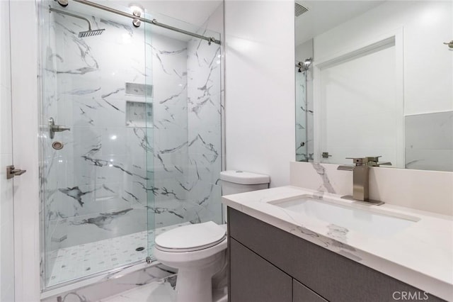 bathroom with vanity, toilet, and a shower with door