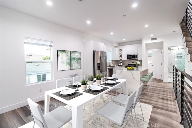 dining space with wood-type flooring and sink