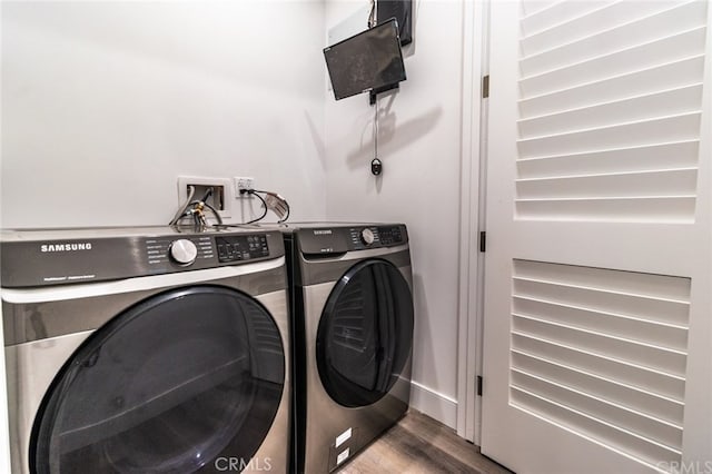 laundry room with independent washer and dryer and hardwood / wood-style flooring