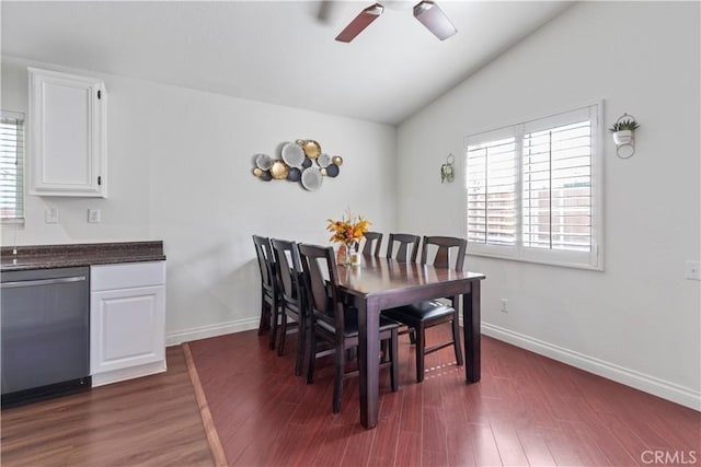 dining space featuring dark hardwood / wood-style floors, vaulted ceiling, and ceiling fan