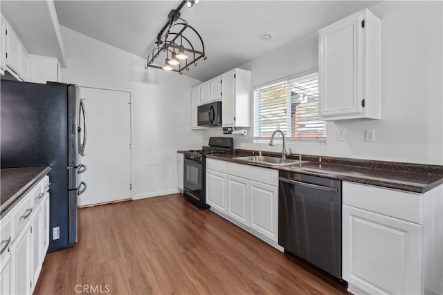 kitchen featuring lofted ceiling, black appliances, sink, dark hardwood / wood-style floors, and white cabinetry