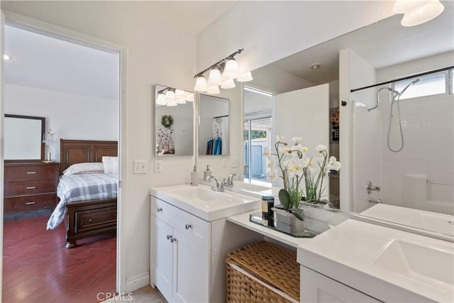 bathroom featuring  shower combination, hardwood / wood-style floors, vanity, and a healthy amount of sunlight