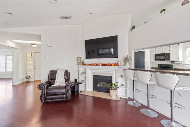 living room with hardwood / wood-style floors, a wealth of natural light, and lofted ceiling