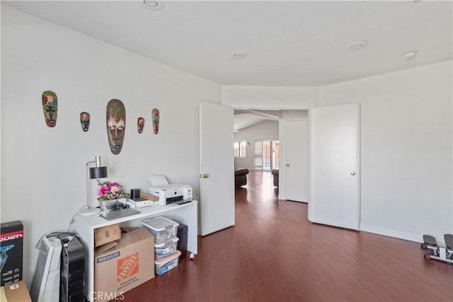 interior space featuring vaulted ceiling and dark wood-type flooring