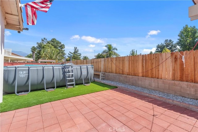 view of patio with a fenced in pool