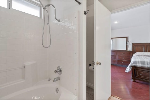 bathroom with hardwood / wood-style flooring and tiled shower / bath combo