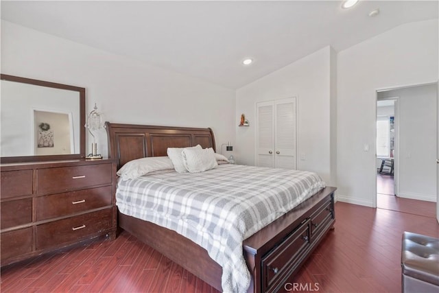 bedroom featuring dark hardwood / wood-style floors, a closet, and lofted ceiling