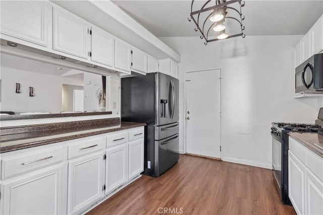 kitchen featuring white cabinetry, dark wood-type flooring, black appliances, and vaulted ceiling