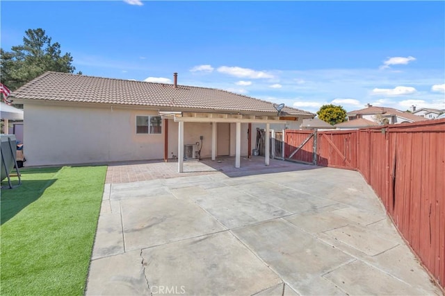 back of house with central AC unit, a yard, and a patio