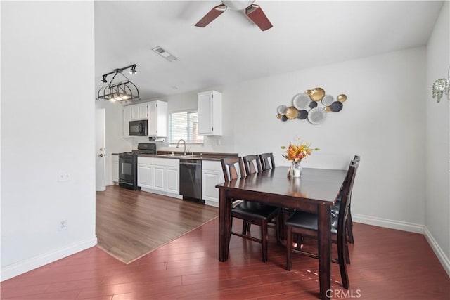 dining area with ceiling fan, sink, and dark hardwood / wood-style floors