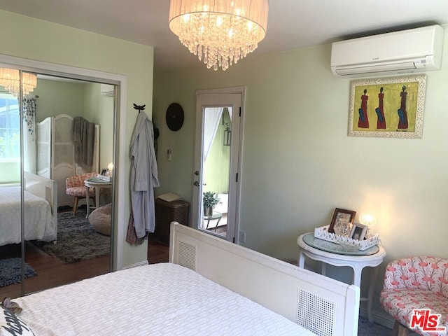 bedroom with an inviting chandelier, dark wood-type flooring, a closet, and a wall mounted AC