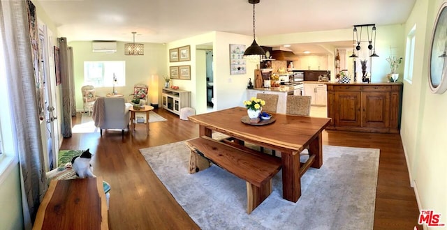 dining room with wood-type flooring and a wall mounted air conditioner