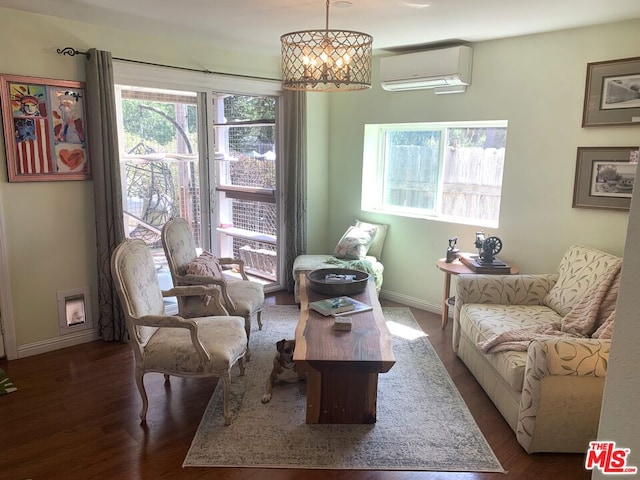 sitting room with dark wood-type flooring, an inviting chandelier, and an AC wall unit